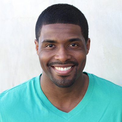 An elderly couple sitting together, smiling and posing for a photo.