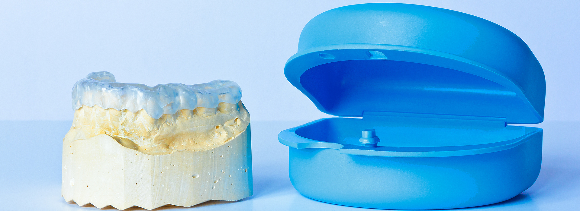 An image showing a blue toothbrush and a yellow dental implant.