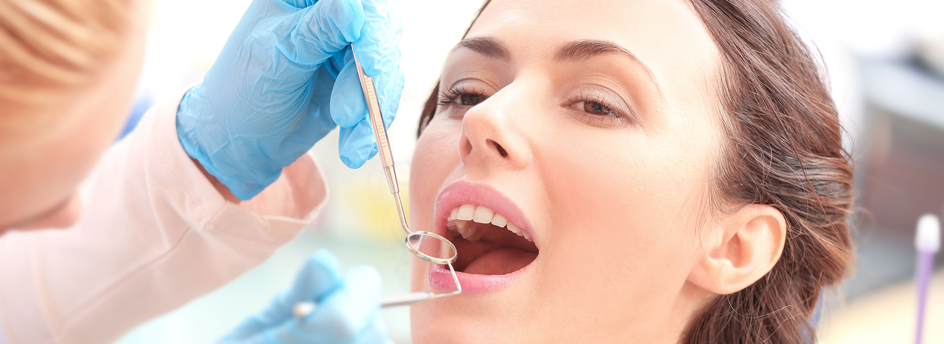 A dental professional performing a teeth whitening procedure on a patient.