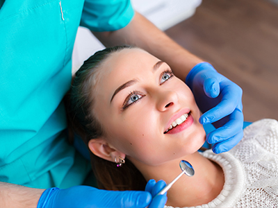 A dental hygienist is performing a teeth cleaning procedure on a patient.